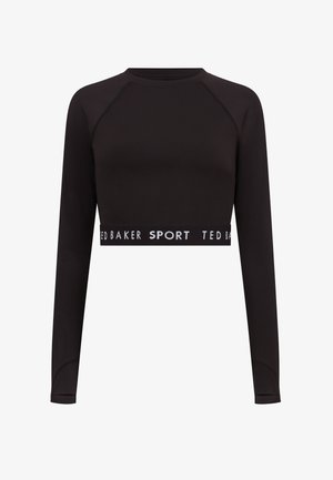 Juodas ilgomis rankovėmis trumpas viršus, pagamintas iš elastingos medžiagos, su apvaliu iškirpimu. Pabrėžia kontrastingą baltą logotipo juostą palei apačią.