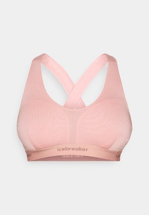 Light pink sports bra with a seamless, soft texture, featuring a crossback design and a logo band at the bottom.