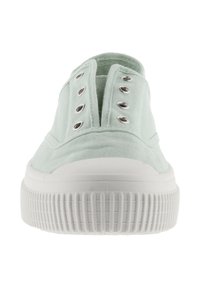 Zapatilla de lona verde claro vista desde el frente con suela de goma blanca y seis ojales metálicos a cada lado sin cordones.