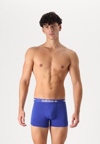 Kék pamut boxer alsónadrág, fitted dizájnnal és fehér márkázott derékkal. Az anyag simának tűnik, enyhe fénylással.