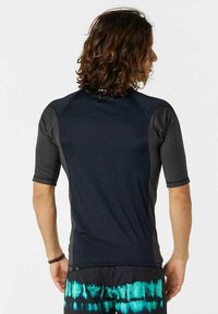 Kortærmet sort rash guard med raglanærmer, glat tekstur, kontrasterende grå sidelapper og et logo på den bageste krave.