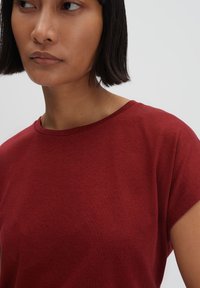 T-shirt rosso a maniche corte realizzato in tessuto morbido, con scollatura rotonda e vestibilità comoda. Texture liscia, dettagli minimi.