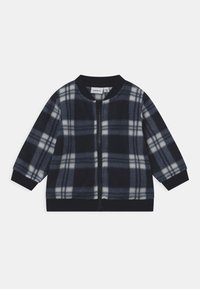 Marineblau karierter Fleece-Jacke mit langen Ärmeln, gerippten B�ündchen und Kragen. Sie verfügt über einen frontalen Reißverschluss und hellgraue Karos auf dunklem Hintergrund.