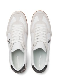 Baskets blanches en daim et cuir, avec un dessus texturé, des lacets plats et un accent de talon noir contrastant.