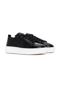 Black leather sneakers with a textured surface, featuring a white rubber sole, round toe, and traditional lace-up design.