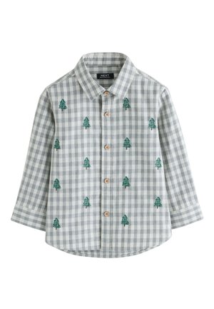 Chemise à manches longues à carreaux gris et blanc avec des boutons marron et des sapins verts brodés dispersés sur le tissu.