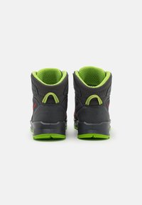 Scarpe alte nere e grigie con accenti verdi, dotate di collari imbottiti, superfici texturizzate e suole in gomma prominenti per una migliore trazione.