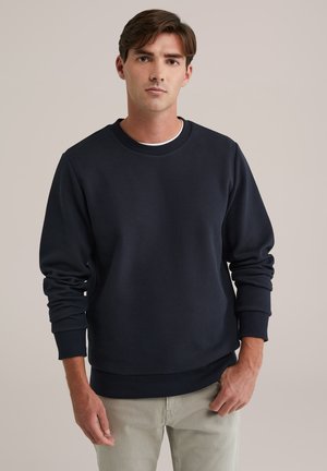 Marineblauwe sweatshirt van textuurstof, met geribbelde ronde hals en boorden. De pasvorm is relaxed, met een rechte zoom en zonder versieringen.