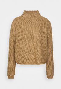 Maglione chunky in marrone chiaro, con un collo alto, maniche lunghe e un motivo testurizzato simile a una waffle. Orlo arrotondato.