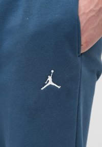 Αθλητικό παντελόνι φόρμας σε ναυτικό μπλε, με λευκό λογότυπο Jumpman. Κατασκευασμένο από απαλό ύφασμα, με λεία υφή και πλαϊνές τσέπες.