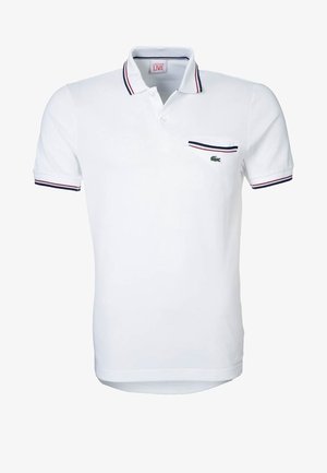 Weißes kurzärmeliges Poloshirt mit rot-blau gestreiftem Besatz an Kragen, Ärmelbündchen und Brusttasche, mit kleinem grünem Krokodil-Logo.