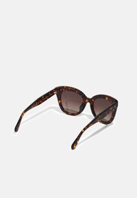 Tortoiseshell sunglasses with a rounded shape, dark tinted lenses, and slightly elongated arms featuring brown and amber pattern accents.