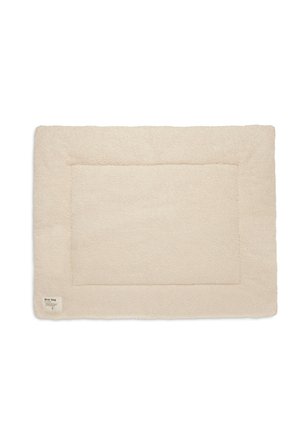 Cream-colored rectangular pet mat with a soft, textured surface and a stitched border. Features a small label in one corner.