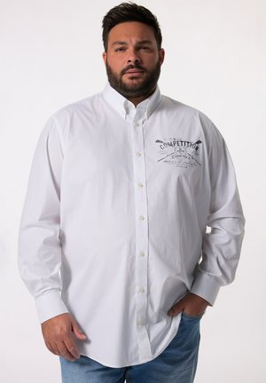 Camisa blanca de manga larga con cuello abotonado. Presenta un diseño impreso en el lado izquierdo del pecho. Textura suave y corte clásico.