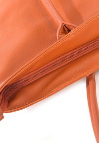 Borsa a tracolla in pelle arancione con una superficie textured, dotata di chiusura a zip e cuciture scure a contrasto. L'interno presenta una fodera liscia.