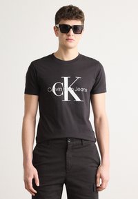 Calvin Klein Jeans - GLOSSY MONOLOGO TEE - Print T-shirt - black Thumbnail Image 1