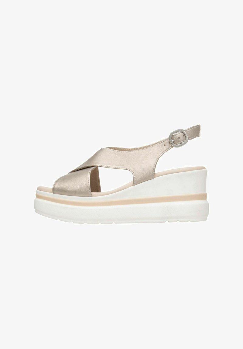 Sandales compensées beige métallisées, avec une ouverture à l'avant, un design à brides croisées, une boucle ajustable à la cheville et une semelle texturée blanche.