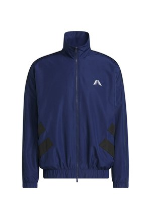 Veste zippée bleu marine avec col montant, poignets et ourlet élastiques, rayures noires diagonales près des poches, et petit logo triangulaire blanc sur la poitrine.