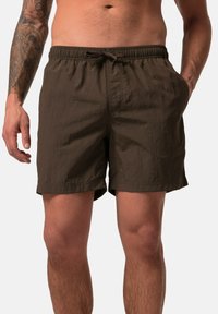 Costumi da bagno marroni con cintura elastica e cordoncino, due tasche laterali e una finitura in tessuto texture.