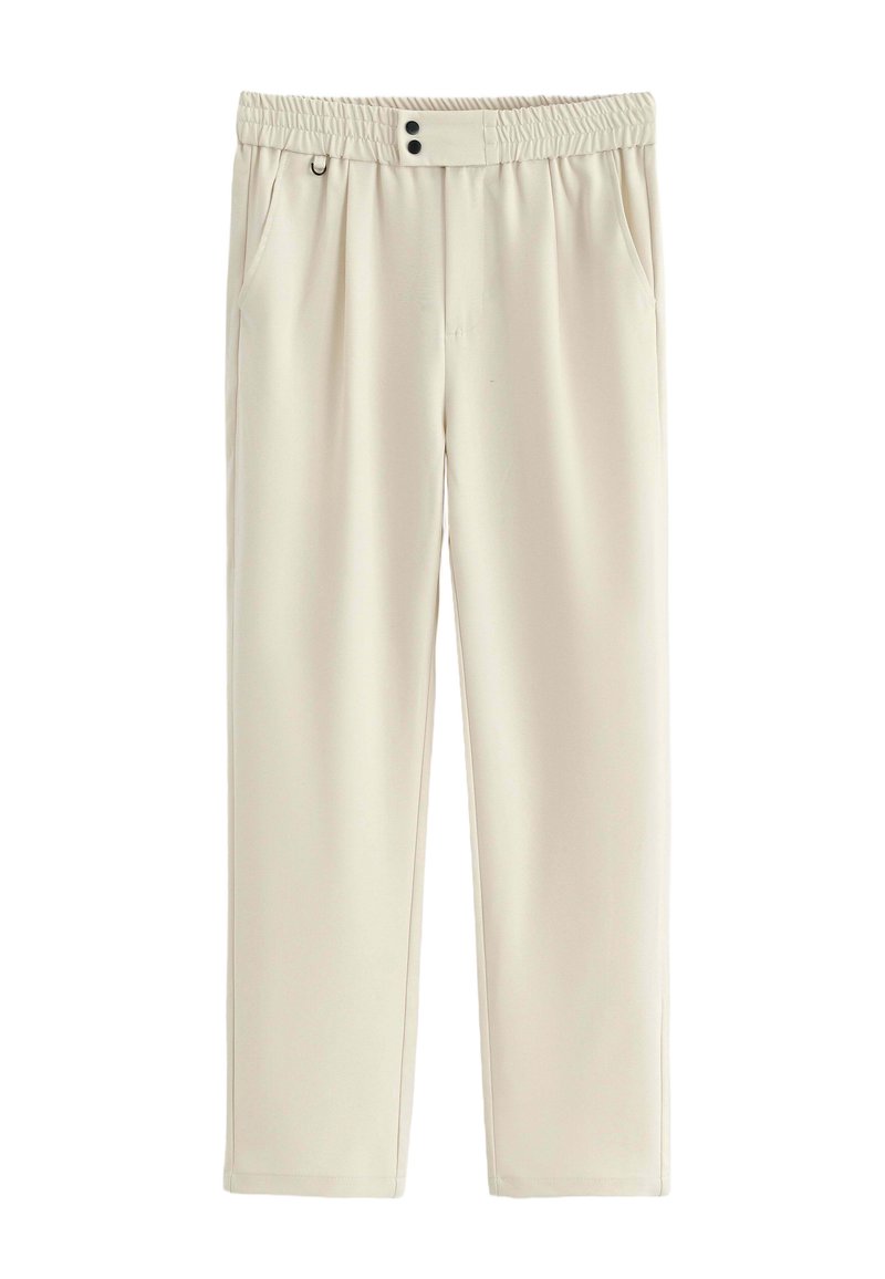 Pantalon de couleur crème avec une texture lisse, taille élastique, deux poches avant et deux boutons décoratifs à la taille.