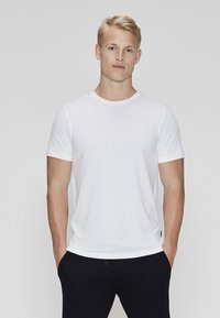 Hvid kortærmet T-shirt med rund halsudskæring og slim fit design. Fremstillet af blødt stof med minimal branding på brystet.