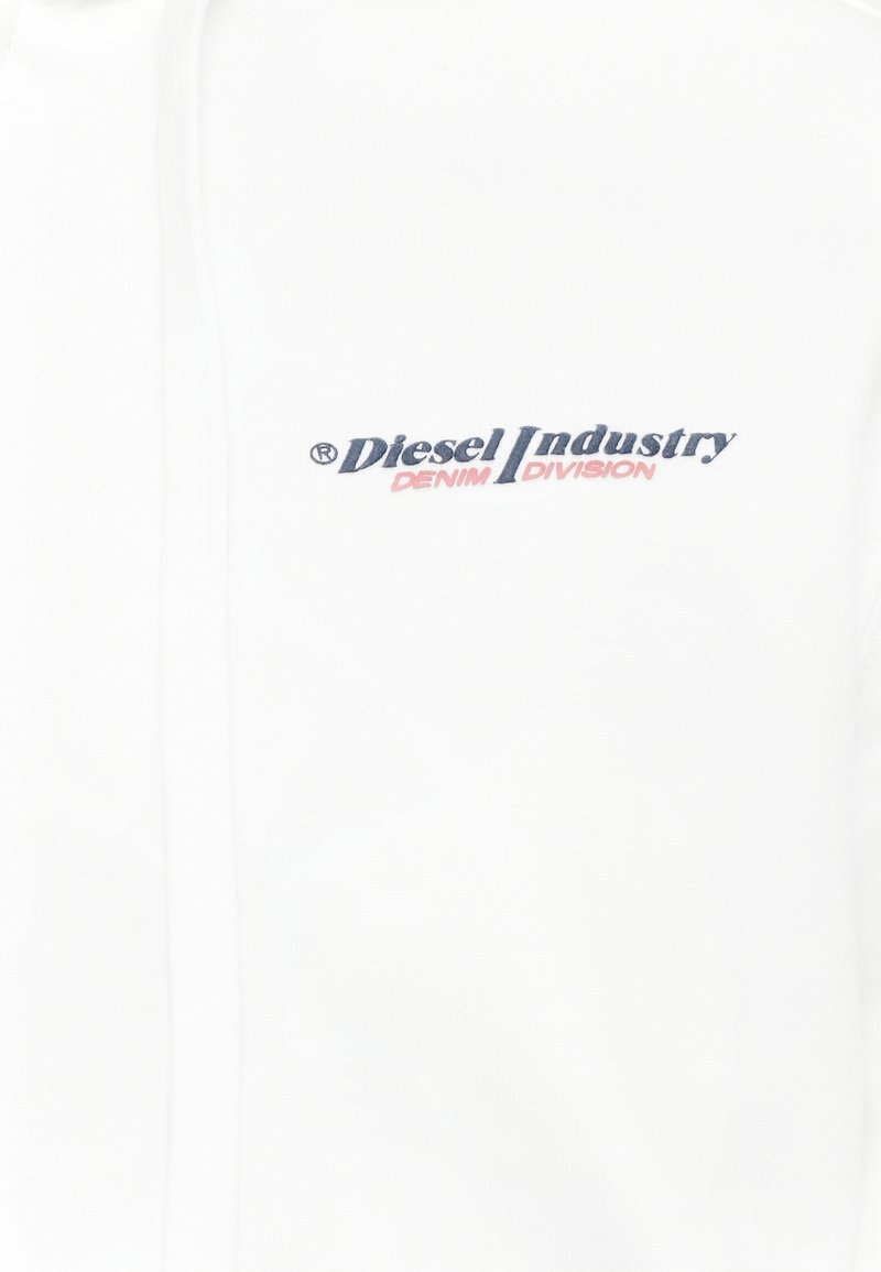 Biała tkanina z haftowanym na górnej części klatki piersiowej logo "Diesel Industry Denim Division" w kolorze niebieskim i różowym.