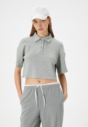 Ljusgrå, kortärmad polo med krage, som har tre knappar och en mjuk textur, i kombination med matchande randiga byxor.