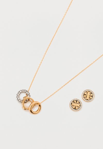 Collier en ton doré avec des pendentifs circulaires entrelacés, l'un mettant en avant des cristaux transparents. Une paire de boucles d'oreilles rondes avec des accents en cristal.