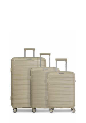 Trois valises coquille dure beiges en tailles petite, moyenne et grande avec des poignées extensibles et quatre roues pivotantes chacune.