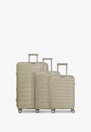 Drie beige hardcase koffers in kleine, middelgrote en grote maten met uitschuifbare handgrepen en elk vier zwenkwielen.