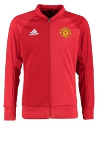Veste rouge Manchester United à fermeture éclair intégrale avec logo Adidas sur la poitrine droite et écusson du club sur la poitrine gauche, manches longues, poignets et ourlet côtelés.