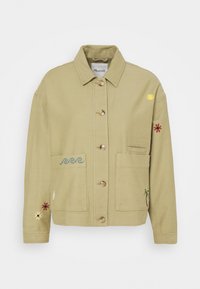 Beżowa kurtka zapinana na guziki z kołnierzykiem, dwoma przednimi kieszeniami oraz małymi haftowanymi wzorami, w tym falami, słońcem, palmą i kwiatami.