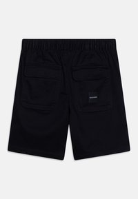 Černé bavlněné šortky s elastickým pasem, dvěma zadními kapsami a malou logovou nášivkou umístěnou uprostřed pravé kapsy. Bez vzorované tkaniny.