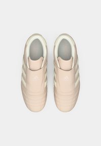 Gaiši rozā čība ar slaidām zolēm un trim baltām svītrām, teksturēts augšdaļa, mīkstināta apmale un iegravēta loģotipa uz mēles.