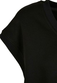 Haut en maille noir à manches courtes avec col en V côtelé et poignets de manches côtelés.
