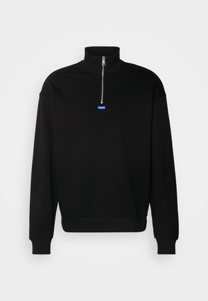 Sudadera negra de pullover hecha de material suave, con un alto cuello y media cremallera. Presenta un logotipo rectangular azul en el pecho.