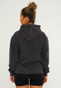 Dunkelgrauer Kapuzenpullover, Relaxed Fit, gerippte Bündchen und Saum, weiche Textur, mit Steppdetails und einer klassischen Kängurutasche.