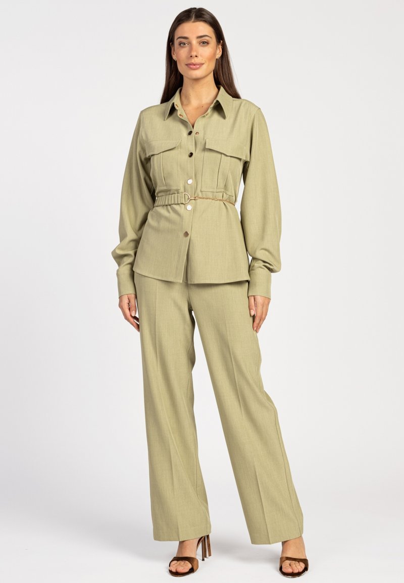 Olive green, long-sleeve belted shirt with two front pockets and button closure, paired with matching wide-leg trousers and heeled sandals.