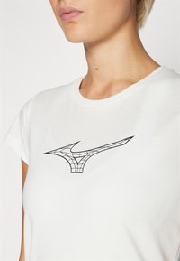 White t-shirt with a short sleeve and a round neckline. Features a black geometric design of a logo on the front.