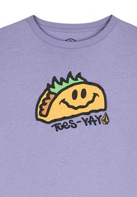 Lichtpaarse T-shirt met een afbeelding van een lachende taco, voorzien van groene sla en de tekst "Tues-YAY" in het zwart onder de taco.