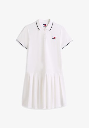 Robe polo blanche à manches courtes avec bordure noire sur le col et les manches, patte de boutonnage, jupe plissée, et petit logo Tommy Jeans sur la poitrine.