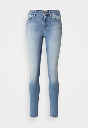 Tynne jeans i lys blå denim med en falmet effekt, fem lommer og rå kant ved anklene. Jeansen har en glatt tekstur og et klassisk design.