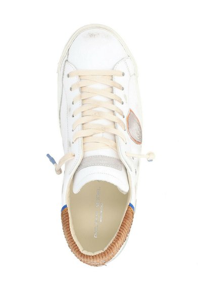 Sneaker in pelle bianca con lacci beige, accenti intrecciati marroni e dettagli blu. Presenta una punta arrotondata e una texture liscia.