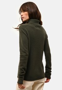 Ciemnozielony, dziergany sweter z golfem, z długimi rękawami i teksturowanym wykończeniem. Posiada żebrowany kołnierz i dół.