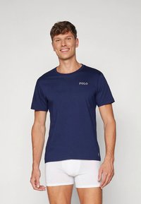 Marineblå bomulls-T-skjorte med korte ermer, rund hals og "POLO"-logo i hvitt på brystet. Klassisk passform.