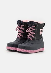 Bottes imperméables noires avec doublure en fausse fourrure rose, lacets roses et accents en forme de cœur sur le côté. Semelle en caoutchouc texturée.