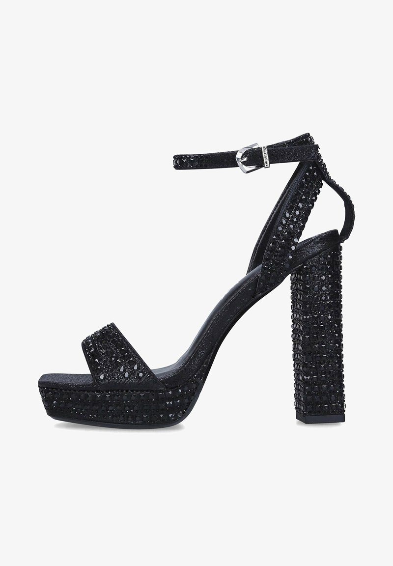 Sandale à talon haut plateforme noire avec bride à la cheville, recouverte de petits clous noirs brillants, avec un talon bloc.