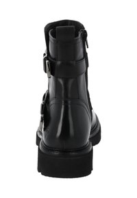 Botín de cuero negro hasta el tobillo con acabado suave, acentos de metal, cremallera lateral y una suela de goma resistente con fondo texturizado.