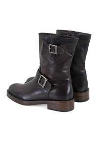 Braune Leder-Stiefeletten mit leicht strukturiertem Finish, seitlichem Riemen und Metallschnalle sowie einem Blockabsatz aus Holz.