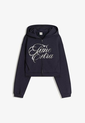 Navy cropped huppari pehmeästä kankaasta, jossa on hopeinen metallinen slogan "Extra" koristeellisilla tähdillä, etuvetoketju ja ribbireunat.
